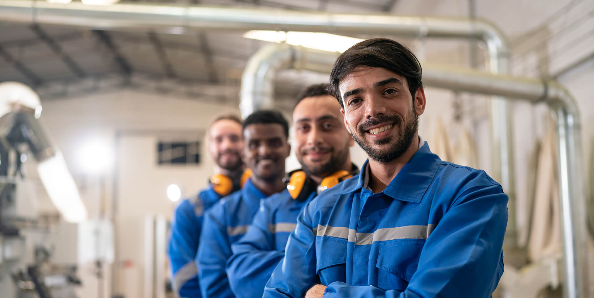 Operários em fila, sorrindo.