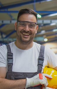 Homem sorrindo no galpão de fábrica
