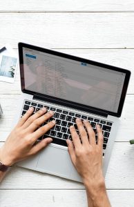 Vista de cima das mãos de uma pessoa trabalhando em um notebook