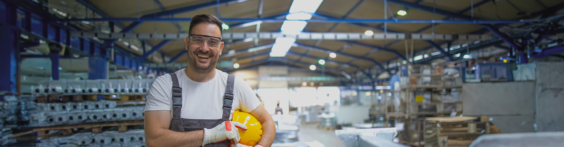Homem sorrindo no galpão de fábrica